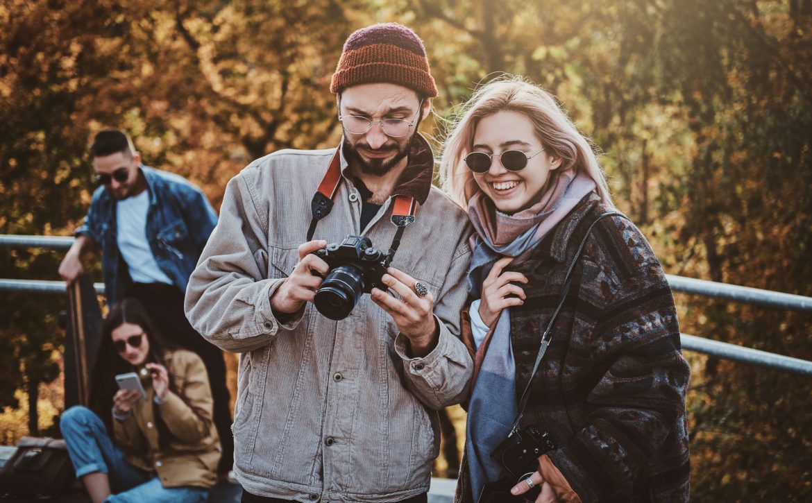 attractive-hipster-is-showing-photos-her-smiling-girlfriend-autumn-park (1)