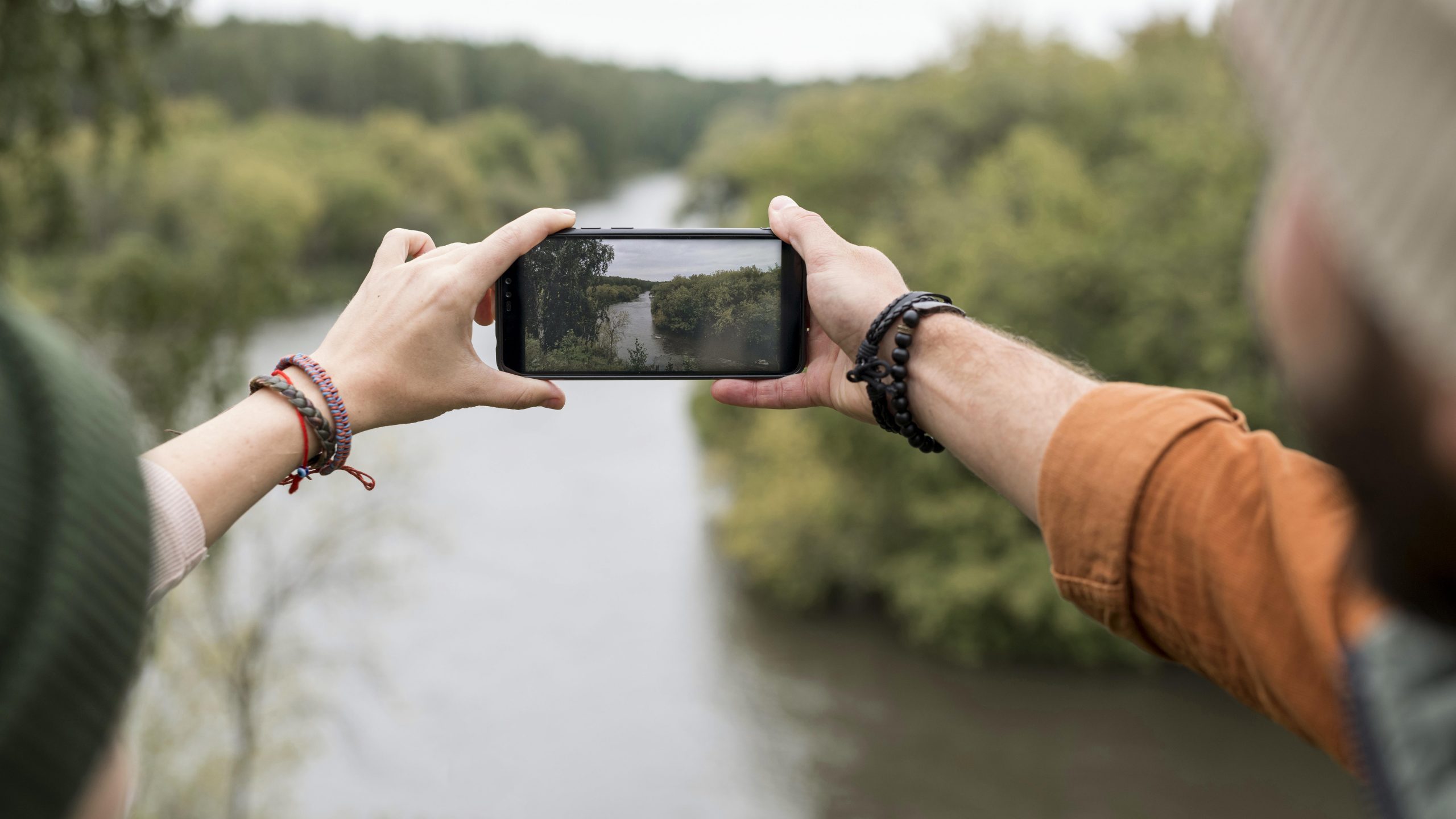 couple-taking-photo-nature-with-smartphone-scaled.jpg